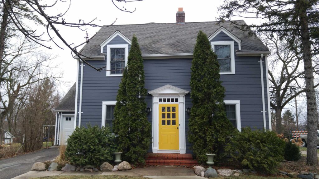 home with yellow door and new siding